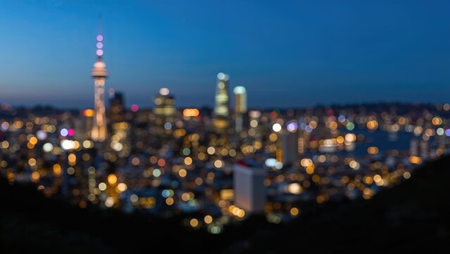 Defocused bokeh of an urban skyline at dusk from a hilltop - Spectacular night panorama with glowing city lights