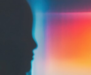 A side profile silhouette of a human head against a colorful gradient background. Creative abstract art for modern design project.