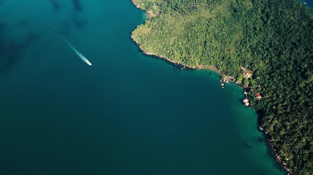 Aerial view of the boat moving fast on the calm bay near the town of Paraty in Brazil