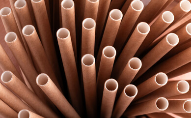 Macro view of brown biodegradable paper straws standing upright in a radial pattern, emphasizing eco-friendly and sustainable lifestyle choices.