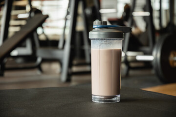 Protein shake bottle at gym. Fitness enthusiasm and post-workout routine. Healthy lifestyle and...