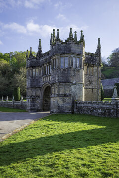 View of a majestic, weathered stone structure rises from a vibrant green lawn under a clear sky, casting long shadows, Bodmin, England, United Kingdom.