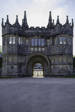 View of the imposing gray stone gatehouse, a medieval marvel with pointed turrets against a soft sky, casts a long shadow, Bodmin, England, United Kingdom.