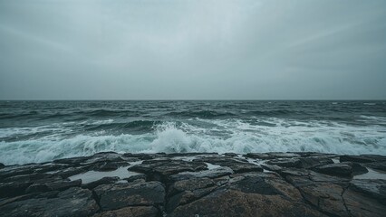 Overcast skies above crashing waves on a rugged shoreline with beautiful scenery
