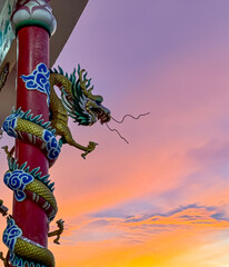 Dragon sculpture, artistically designed with vibrant colors, stands on a pillar against a stunning...