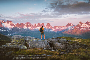 Man traveler hiking solo in Norway mountains extreme travel adventure trip. Active hiker with...