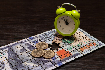 Puzzle Pieces of a $100 Bill, $1 Coin and Alarm Clock