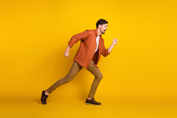 Young man in casual attire enthusiastically posing against a yellow background conveying energy and...