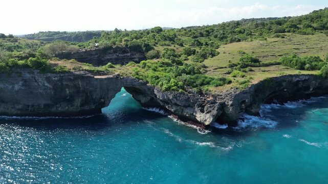 Close-up drone video of the iconic Arch Ole Oli rock formation at Broken Bay Cliff, Nusa Penida. Capturing incredible textures and detail.