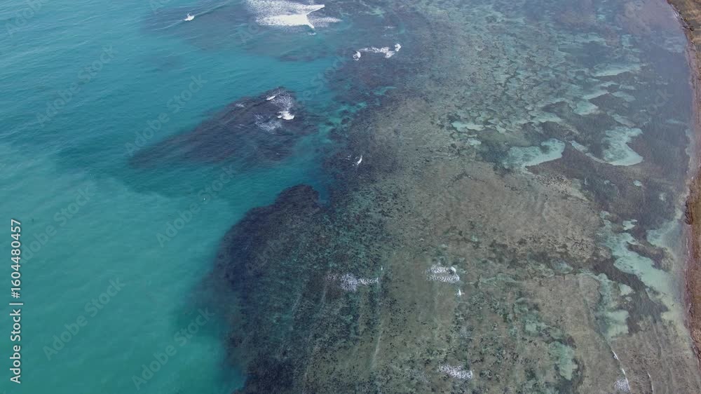 Aufkleber panoramic aerial overview of shallow shoreline fringing reefs with ocean waves crashing during dayti