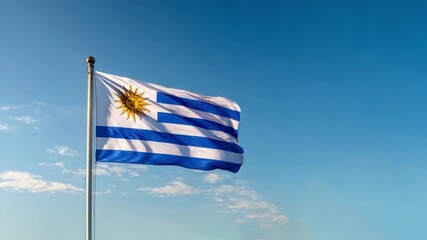 The flag of Uruguay proudly flutters in the wind, showcasing its distinctive stripes and sun emblem under a sunny sky. - Powered by Adobe