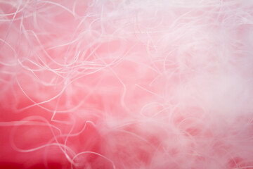 Extreme macro of polyester stable fiber on red background. Selective focus, shallow depth of field. Abstract dreamy background