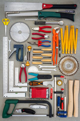 Flat lay of old hand tools on concrete background. Large collection of various rusty tools and bits arranged on concrete.
