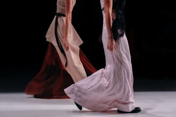 Elegant women fashion, brown dress, pink skirt, chic clothes outfit on black background. Fashion models walking the runway Fashion show