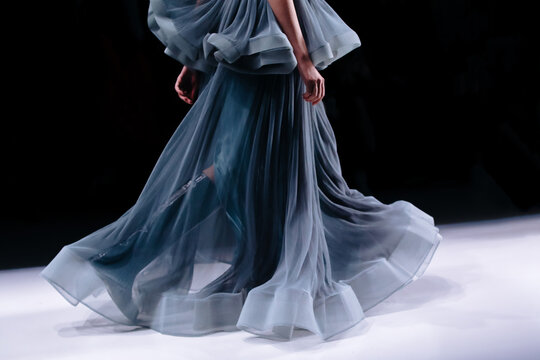 Elegant women fashion,blue satin dress, chic clothes outfit on black background. Fashion model walking the runway fashion show