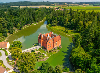 Cervena Lhota Castle, red chateau in the middle of a lake on a rocky island, South Bohemia, Czech...