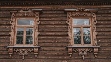 Antique wooden residence showcasing intricately carved window frames, previously the home of merchant Sapozhnikov located at Simanovsky Street, 14 (Sverdlova, 63). Classic Russian architectural