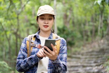 Young Woman Using Smartphone While Hiking in Forest
