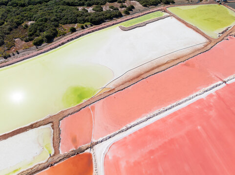 Aerial view of colourful salt evaporation ponds and levee banks at a coastal salt farm