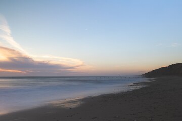Serene beach scene at dusk with colorful sky.