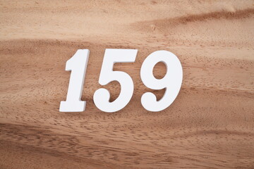 The numbers are made of white painted wood placed on a brown wooden floor.