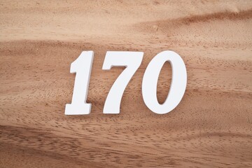 The numbers are made of white painted wood placed on a brown wooden floor.