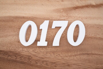 The numbers are made of white painted wood placed on a brown wooden floor.