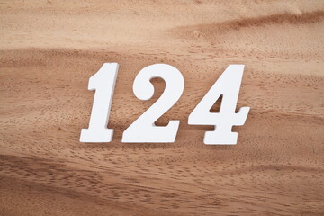 The numbers are made of white painted wood placed on a brown wooden floor.