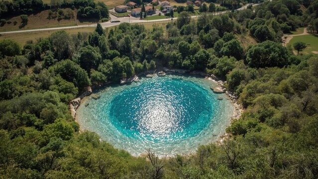 Elevated view showcasing the turquoise spring by the nearby village