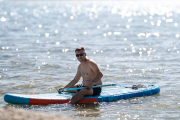 Tourist enjoying paddle boarding in the sparkling sea