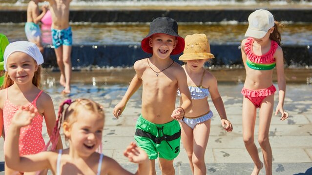 Kids playfully splash around a fountain under clear skies. Concept of summer family leisure ad, sunny outdoor lifestyle promo, seasonal content for parenting blogs