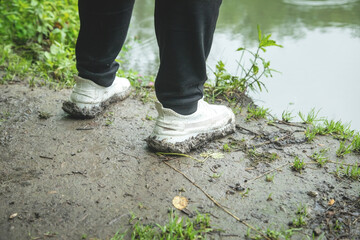 Man with a shoes stands on the dirty ground.