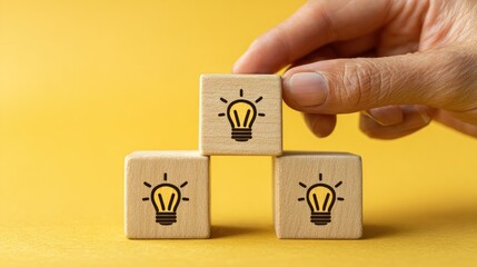 Wooden blocks with lightbulb symbols are being stacked.