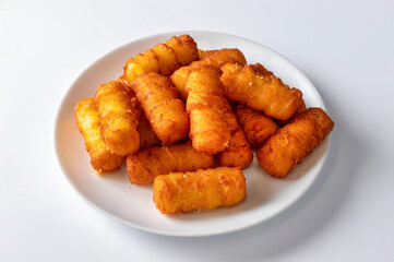 Golden crispy potato croquettes arranged on a white ceramic plate, isolated on white background. Fried finger food snack made from mashed potatoes and breadcrumbs, natural light, horizontal.