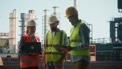 Engineers discussing plans at refinery construction site - Powered by Adobe
