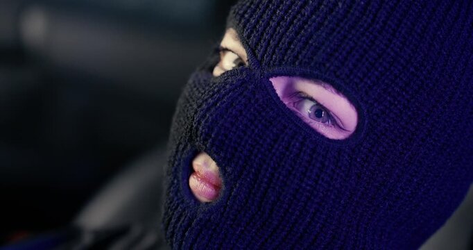 Beautiful Woman Wearing Black Ski Mask, Close-Up on Blue Eyes and Red Lips