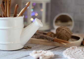 Decorative watering can flower pot crochet hooks collection table different handmade objects on the...