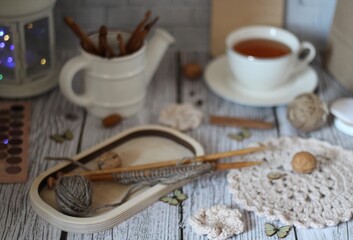 Decorative watering can flower pot crochet hooks collection table different handmade objects on the...