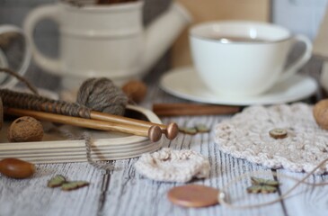 Knitting process, needles, cup of tea and different objects on the table beautiful photo 