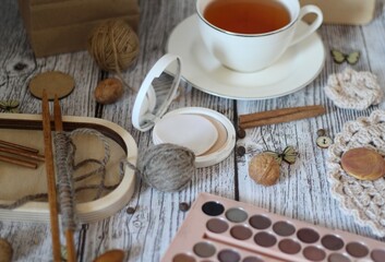 Woman's different things cup of tea, make up, ball clew yarn, mirror doily cozy photo beige pastel...