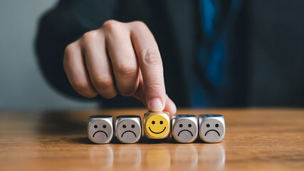 Choosing positivity person selects happy face cube amidst sad faces demonstrating customer satisfaction and positive feedback selection