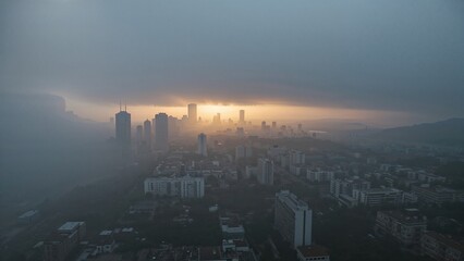 Naklejka premium Foggy winter morning captured from above showing an urban skyline under cloudy skies