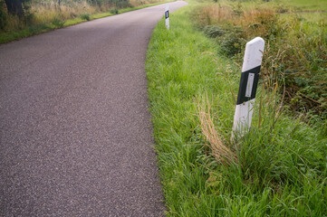 Roadside reflector post marking a curve on a country road