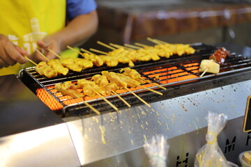 Grilled chicken skewers being prepared at Naka Night Market in Phuket, Thailand, June 2025 — vibrant street food scene full of color and flavor.