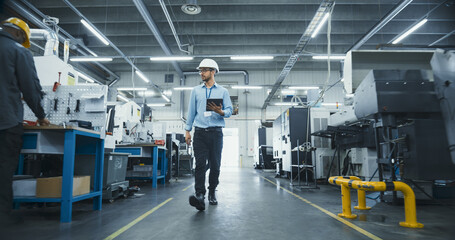 Chief Technical Officer Working at Metal Components Production Factory. Young Middle Eastern Specialist Walking in the Facility, Using Tablet Computer to Monitor the Manufacturing Process