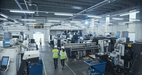 Establishing Footage with Professional Multicultural Colleagues Working at an Industrial Production Plant. Team Producing Metal Components with Heavy Duty Tools and CNC Milling Equipment