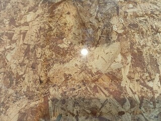 Closeup texture of OSB wood board with glossy surface reflection