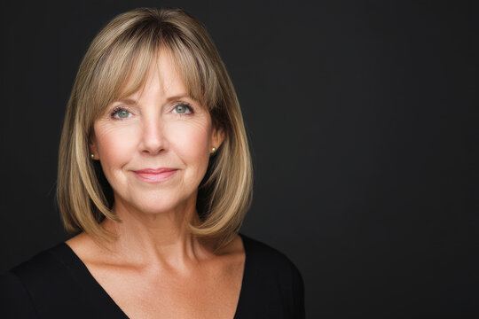 A mature Caucasian businesswoman plans a professional headshot event for staff, coordinating lighting, photographer schedule, and makeup