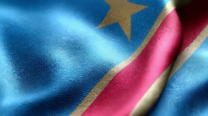 Richly colored flag of the Democratic Republic of the Congo displays its fabric texture and design elements under soft lighting.