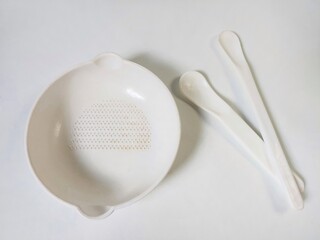 White Set of children's bowl and spoons on the white background. Baby tableware. Nutrition and first level Baby's feeding concept